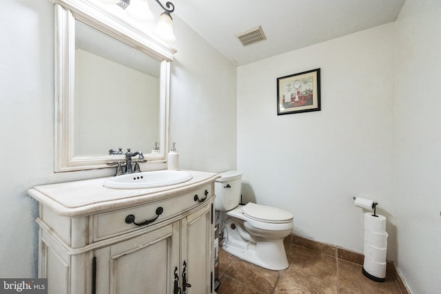 half bathroom featuring vanity, toilet, baseboards, and visible vents