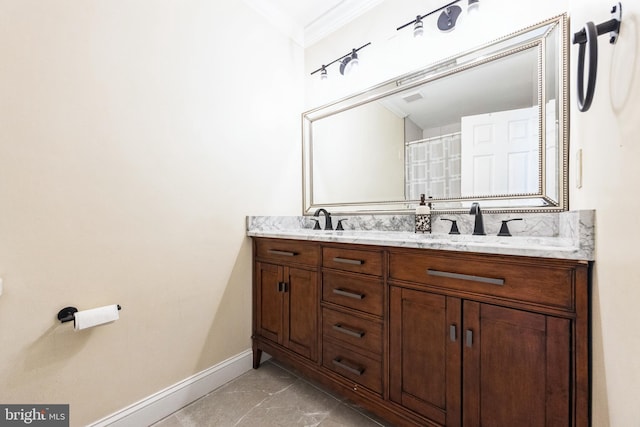 bathroom with baseboards, double vanity, a sink, ornamental molding, and marble finish floor