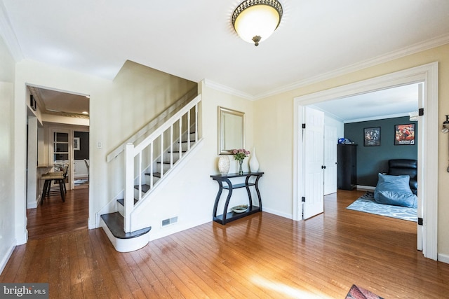 entrance foyer featuring visible vents, crown molding, baseboards, stairs, and hardwood / wood-style floors