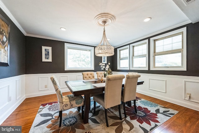 dining area with a wainscoted wall, recessed lighting, crown molding, and wood finished floors