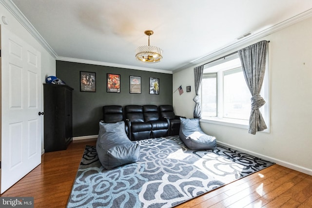 living area with visible vents, crown molding, and hardwood / wood-style flooring