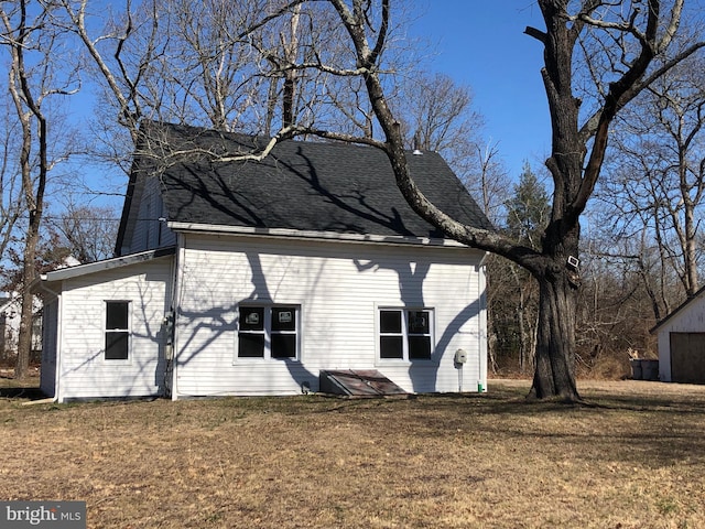 view of home's exterior featuring a lawn and a shingled roof