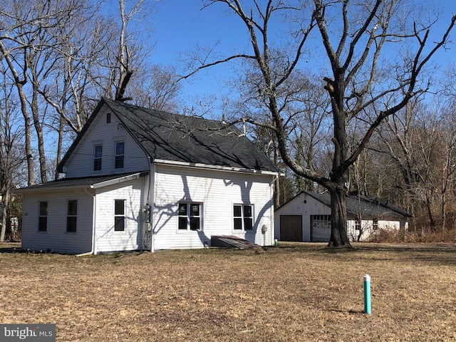 exterior space featuring a detached garage and an outbuilding