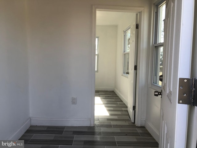 hall with baseboards and wood tiled floor