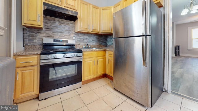 kitchen with light tile patterned floors, tasteful backsplash, appliances with stainless steel finishes, and a sink