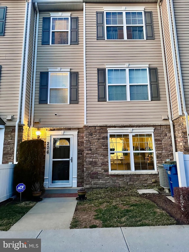 view of front of property featuring central air condition unit and stone siding