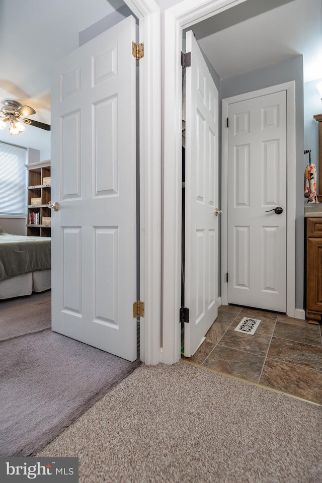 hallway featuring visible vents and dark carpet