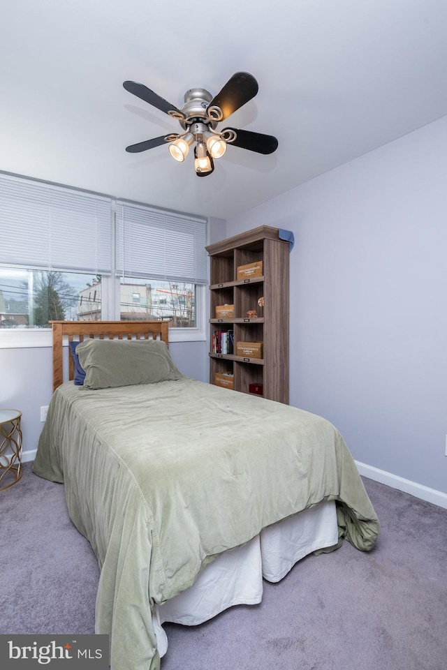 carpeted bedroom with a ceiling fan and baseboards