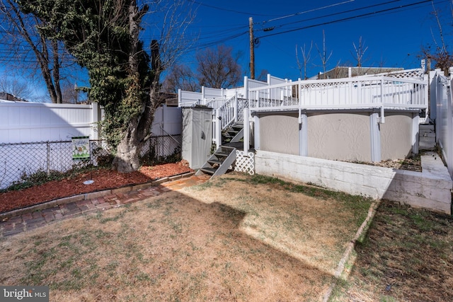 view of front of house featuring a wooden deck, stairway, a front lawn, and fence