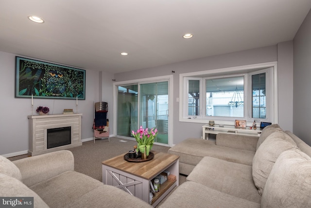 carpeted living room featuring recessed lighting, baseboards, and a glass covered fireplace