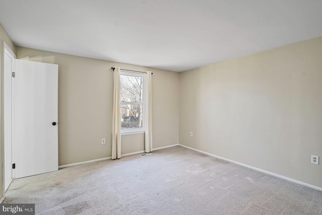 carpeted empty room with visible vents and baseboards