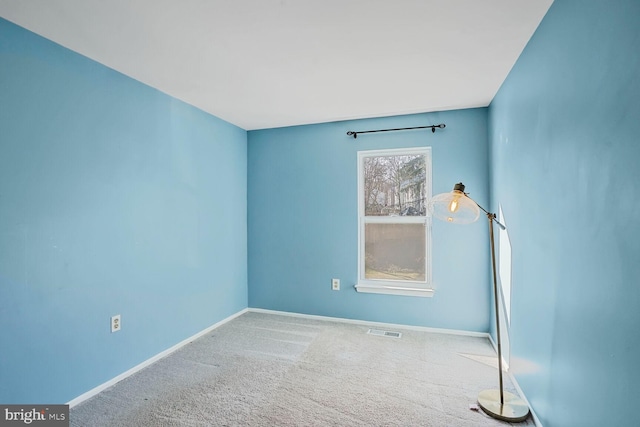 empty room with visible vents, baseboards, and carpet