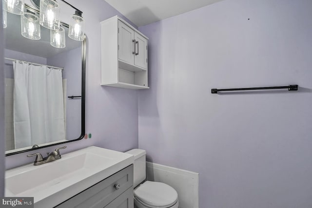 full bath with a shower with shower curtain, toilet, and vanity