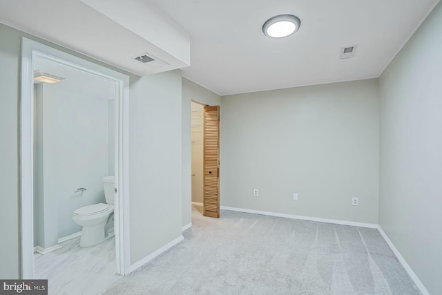 bedroom featuring visible vents, connected bathroom, a walk in closet, baseboards, and carpet flooring