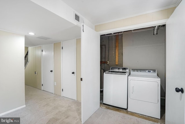 laundry room with light carpet, independent washer and dryer, laundry area, and crown molding