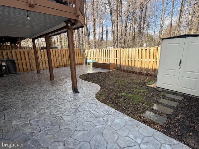 view of yard with a patio, an outbuilding, a fenced backyard, and a shed