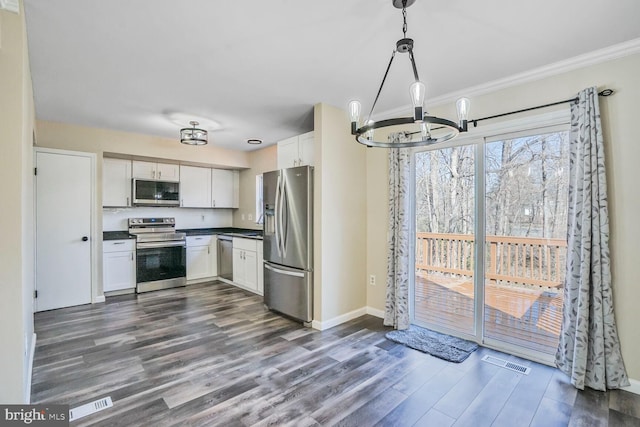 kitchen with dark countertops, visible vents, appliances with stainless steel finishes, dark wood-style floors, and white cabinetry