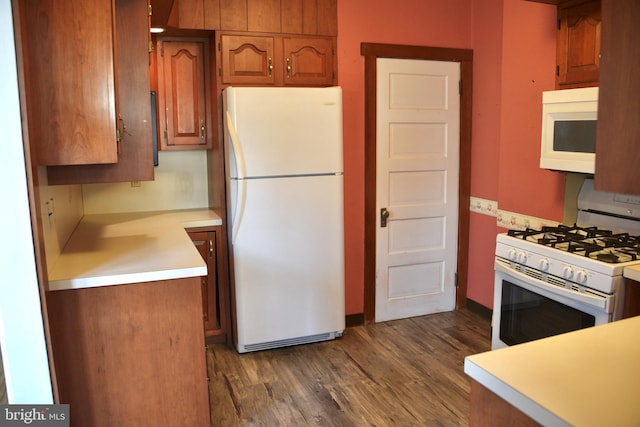 kitchen featuring white appliances, brown cabinets, dark wood finished floors, and light countertops