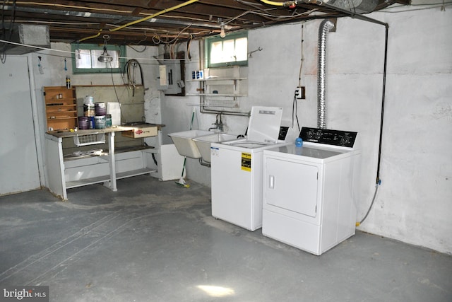 below grade area featuring electric panel, washing machine and dryer, and a sink