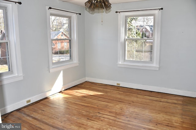 unfurnished dining area with baseboards and wood finished floors