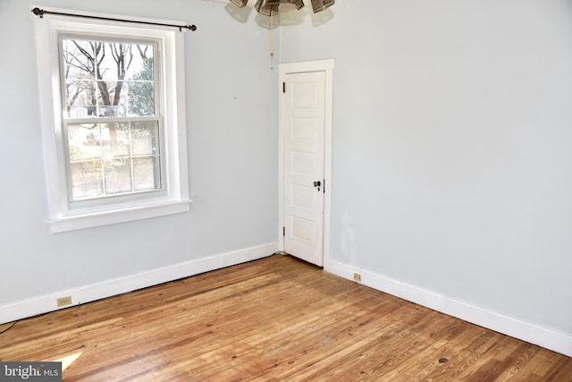 empty room featuring baseboards and light wood-style flooring