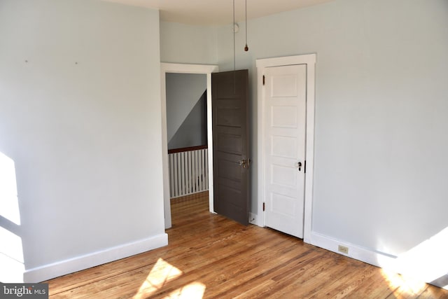 unfurnished room with baseboards and light wood-style floors