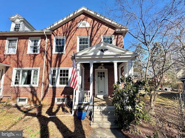 view of front of house with brick siding and a porch