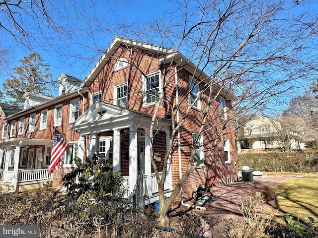 view of side of property featuring brick siding and a porch