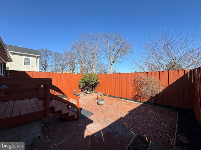 view of yard with a patio area, a fenced backyard, and a wooden deck