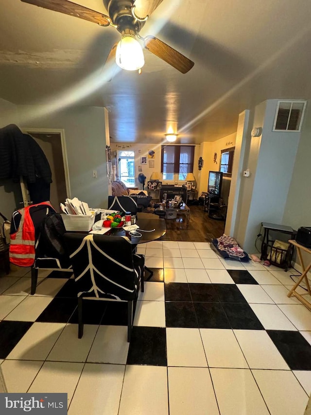 tiled living room with visible vents and a ceiling fan