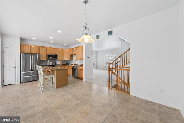 kitchen with visible vents, a kitchen island, recessed lighting, stainless steel appliances, and hanging light fixtures