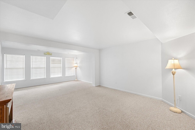 carpeted spare room featuring baseboards and visible vents