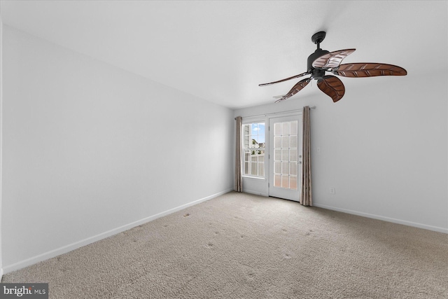 spare room with baseboards, carpet, and a ceiling fan