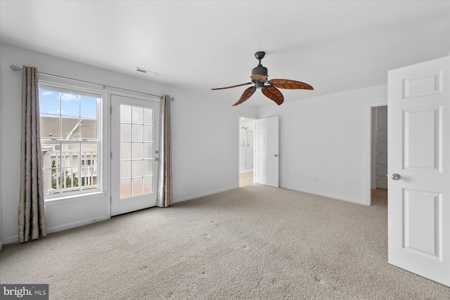 carpeted spare room featuring visible vents, baseboards, and a ceiling fan