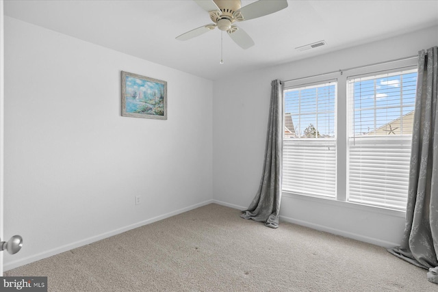 spare room with carpet flooring, a ceiling fan, and baseboards