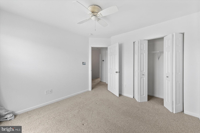 unfurnished bedroom featuring a ceiling fan, light colored carpet, baseboards, and a closet