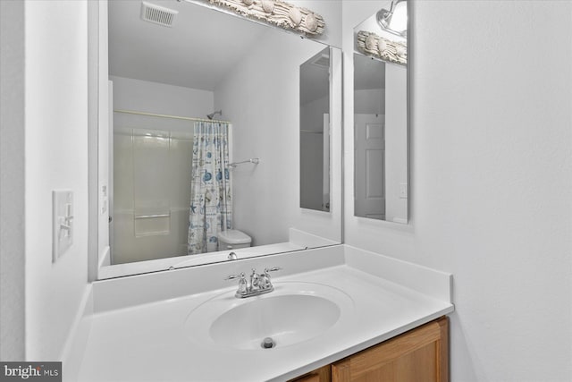 full bathroom with vanity, a shower with shower curtain, toilet, and visible vents