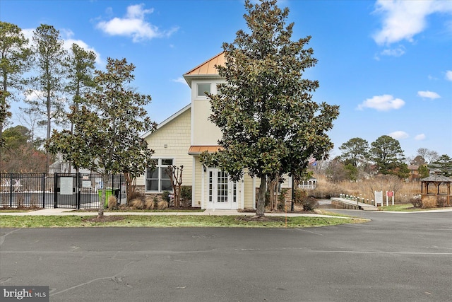 view of front of house featuring a standing seam roof, fence, and metal roof