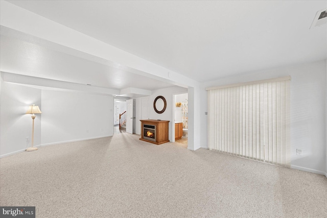 unfurnished living room featuring carpet and baseboards