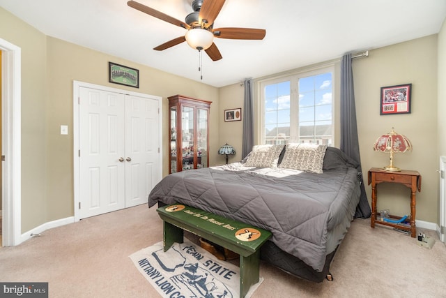 carpeted bedroom with baseboards, a closet, and ceiling fan