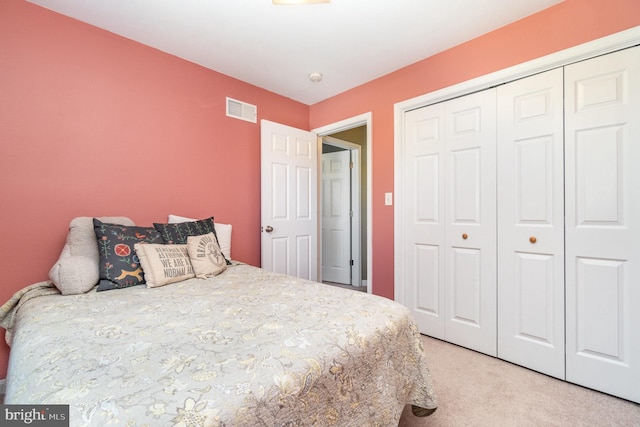 bedroom featuring light carpet, visible vents, and a closet