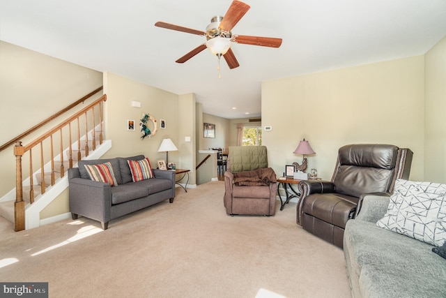 living room with stairs, a ceiling fan, and carpet floors