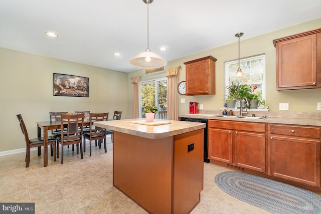 kitchen with light countertops, decorative light fixtures, a center island, and a sink