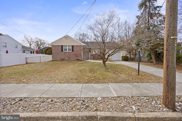 view of front of home featuring fence, concrete driveway, a front yard, a garage, and brick siding