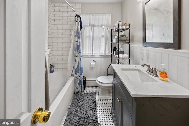 bathroom featuring tile patterned floors, a wainscoted wall, toilet, shower / tub combo, and vanity