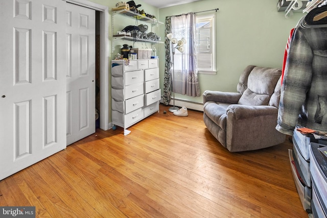 living area featuring hardwood / wood-style flooring and baseboard heating
