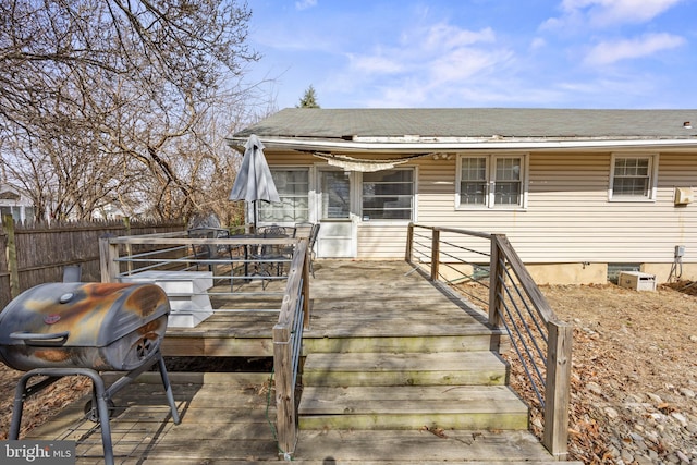 wooden terrace with fence and a grill