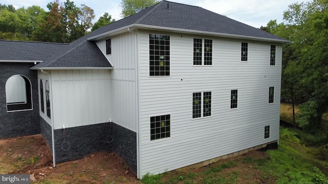 view of side of property with roof with shingles