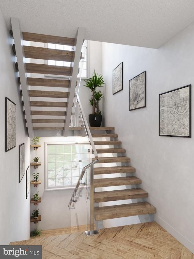 stairs featuring a textured ceiling