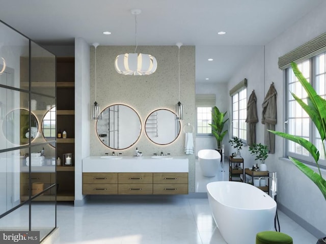 full bathroom with double vanity, a freestanding tub, a healthy amount of sunlight, and recessed lighting